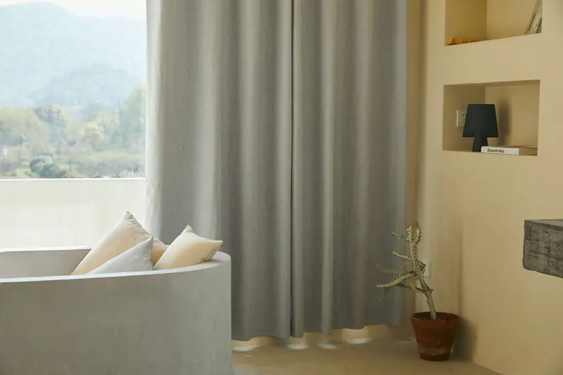 Floor-length grey curtains in a bright, minimalist living room