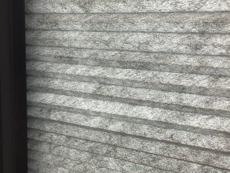 Close-up of a grey honeycomb blind fitted inside a window frame